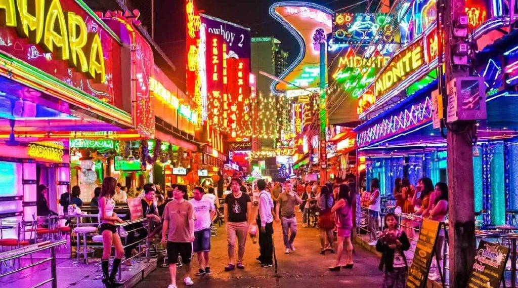 Touristes et filles de bar dans la soi Cowboy à Bangkok