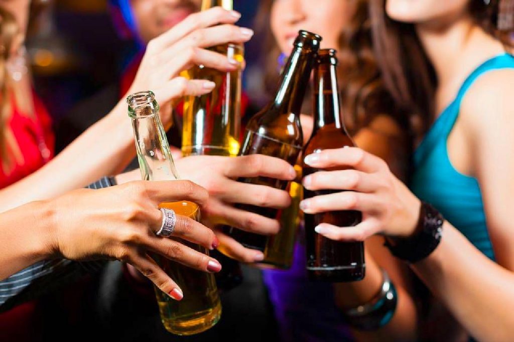 Un groupe de personnes trinque avec des bouteilles d'alcool