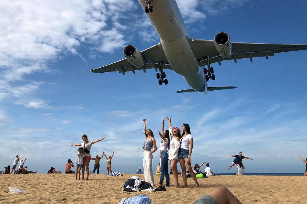Un avion survol des touristes sur une plage de Phuket