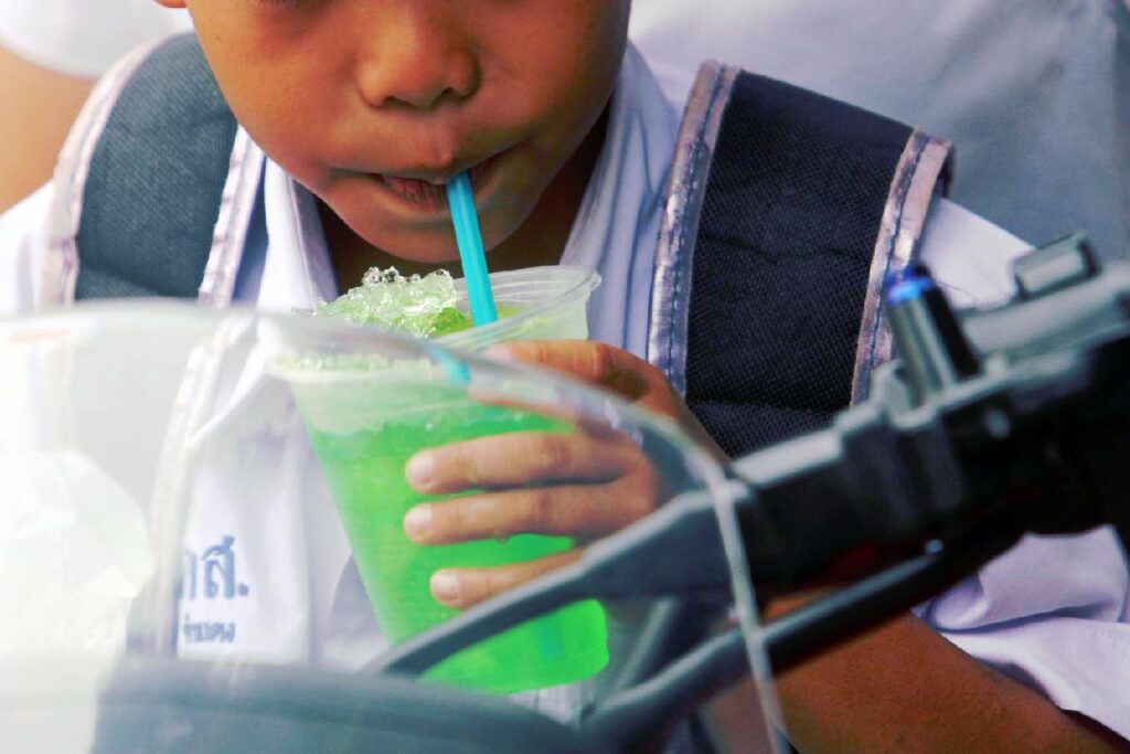 Un enfant thaïlandais avec une boisson sucrée