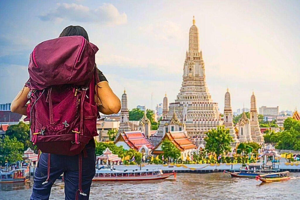 Voyager en Thaïlande malgré le conflit avec le Cambodge : ce qu’il faut savoir (mise à jour 2026) 8 Touriste avec un sac à dos devant le wat Arun à Bangkok