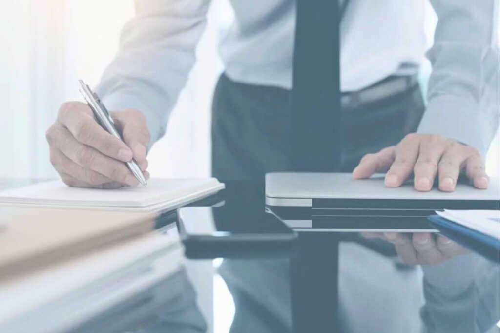 En Thaïlande, un simple avis négatif en ligne peut vous mener en prison 10 Homme signant un document à son bureau, symbolisant une procédure légale