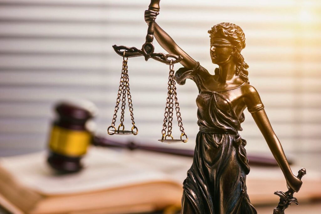 Pollution de l’air en Thaïlande : l’urgence d’une loi face à la crise des PM2,5 9 Statue de femme symbolisant la justice, tenant une balance, posée à côté d’un marteau de juge.