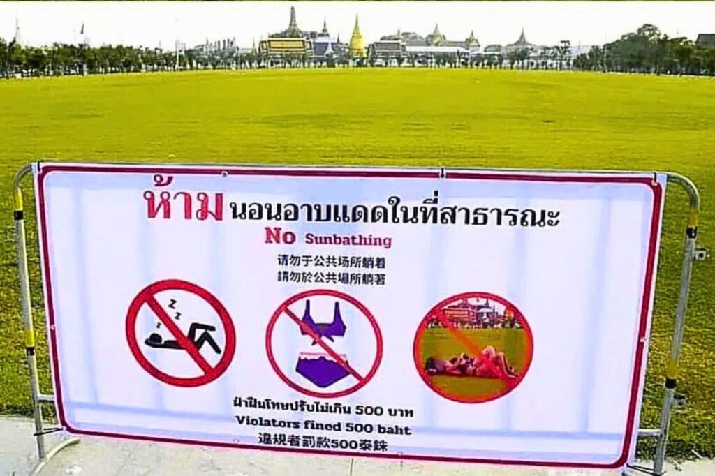 Panneau indiquant que le bronzage et le port de bikini sont interdits dans le parc de Sanam Luang à Bangkok.