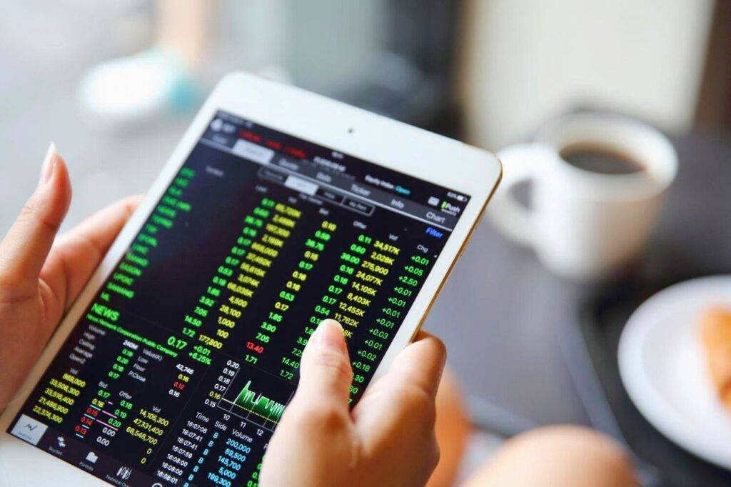 Écran affichant des cours boursiers en hausse sur une tablette.