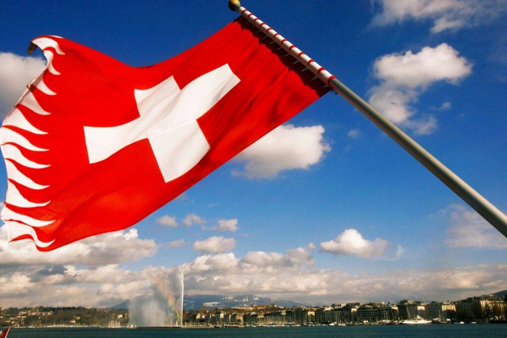 Le drapeau suisse flotte à l'arrière d'un bateau sur le lac de Genève