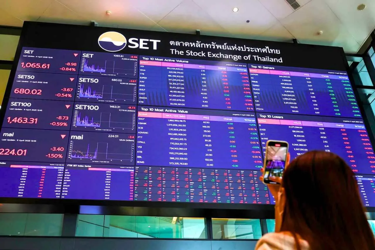 La bourse de Thaïlande termine sa 3e année consécutive dans le rouge 4 Une femme prend en photo un panneau montrant les valeurs du SET