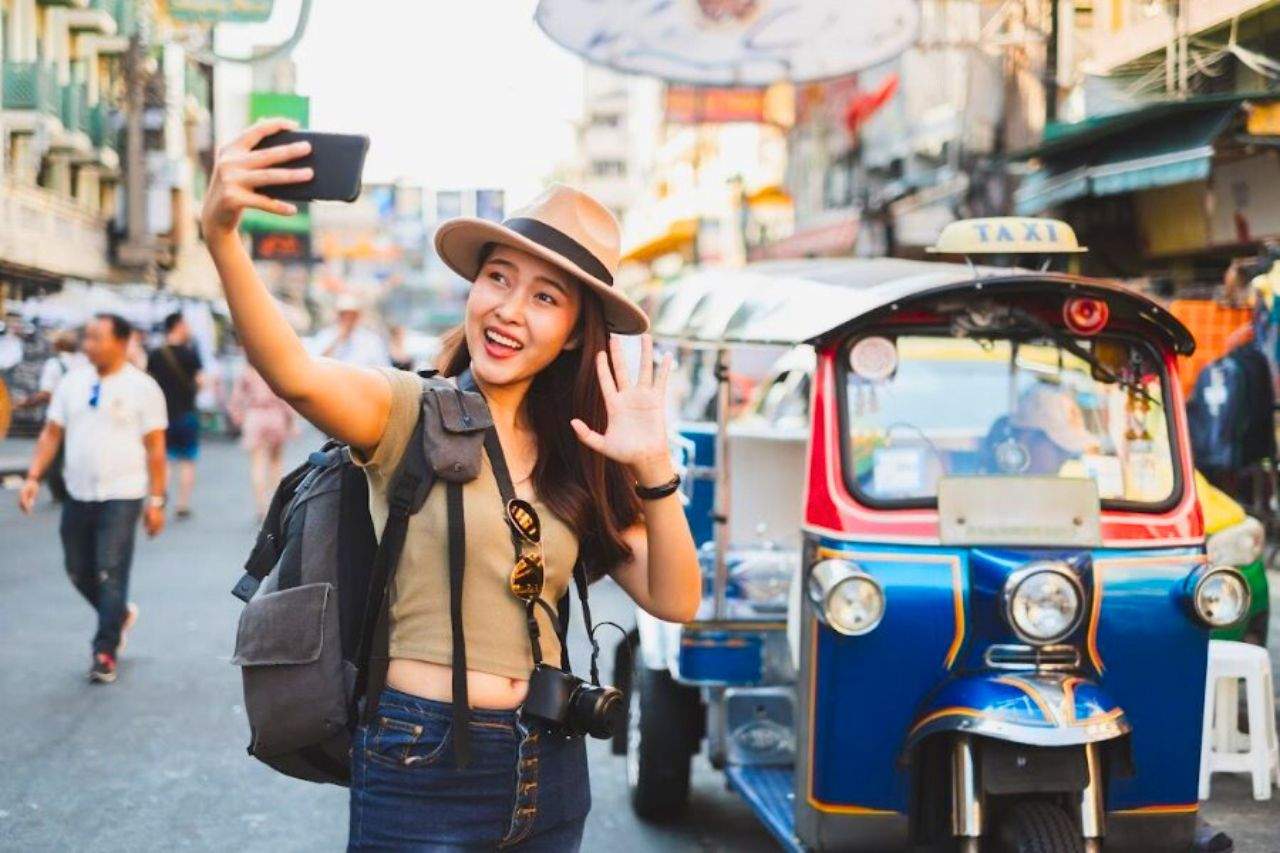 En Thaïlande, un simple avis négatif en ligne peut vous mener en prison 11 Une touriste prend un selfie à Bangkok en face d'un tuk tuk