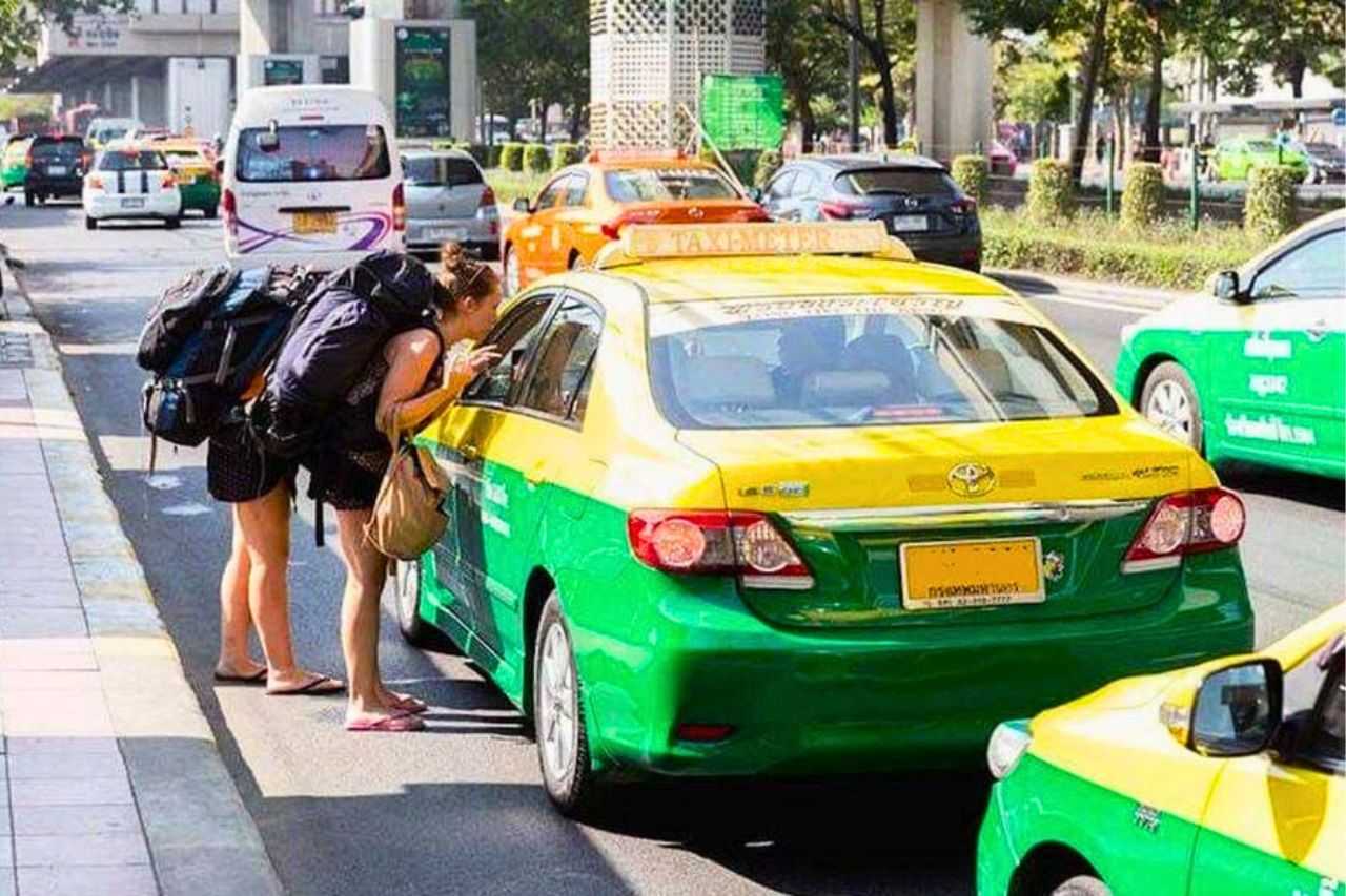 Des touristes s'apprêtent à monter dans un taxi en Thaïlande
