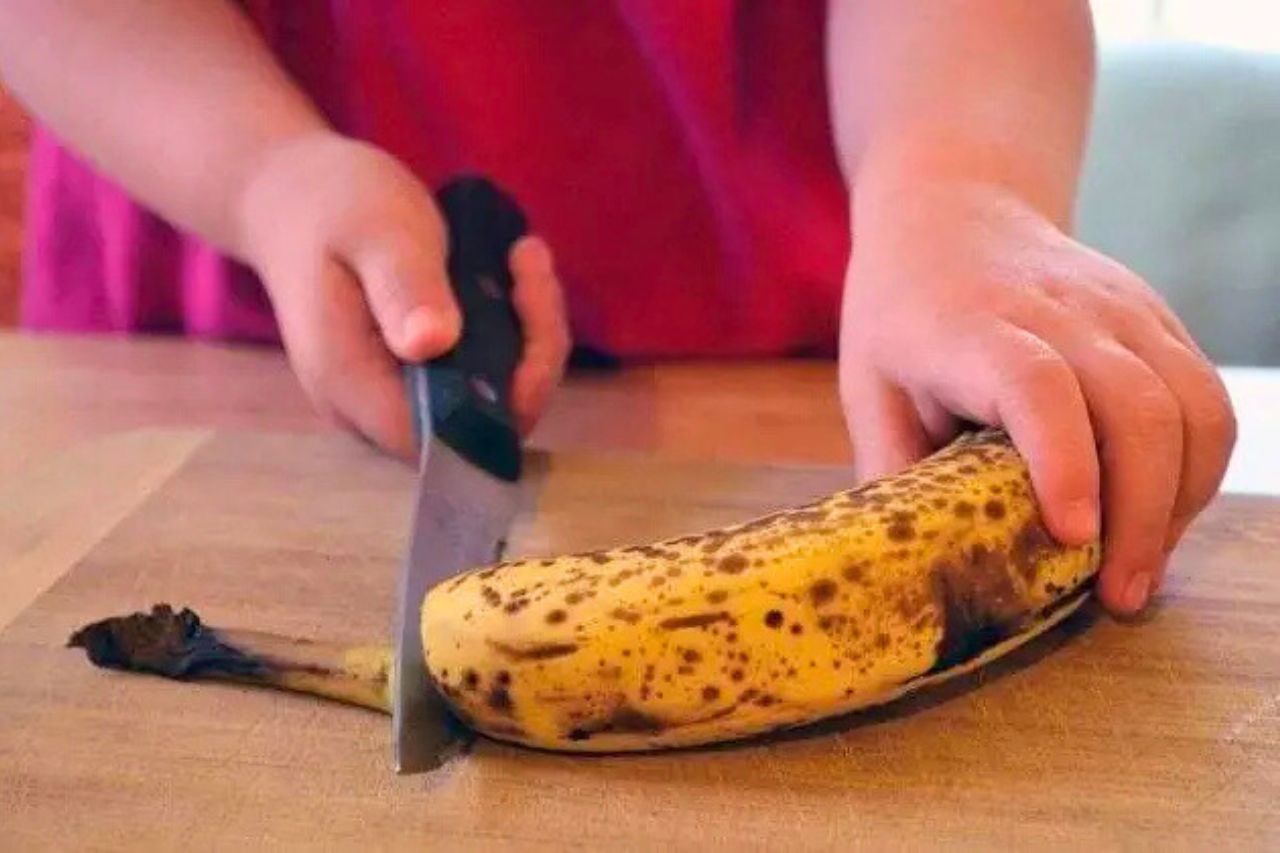 Eine Frau schneidet eine Banane