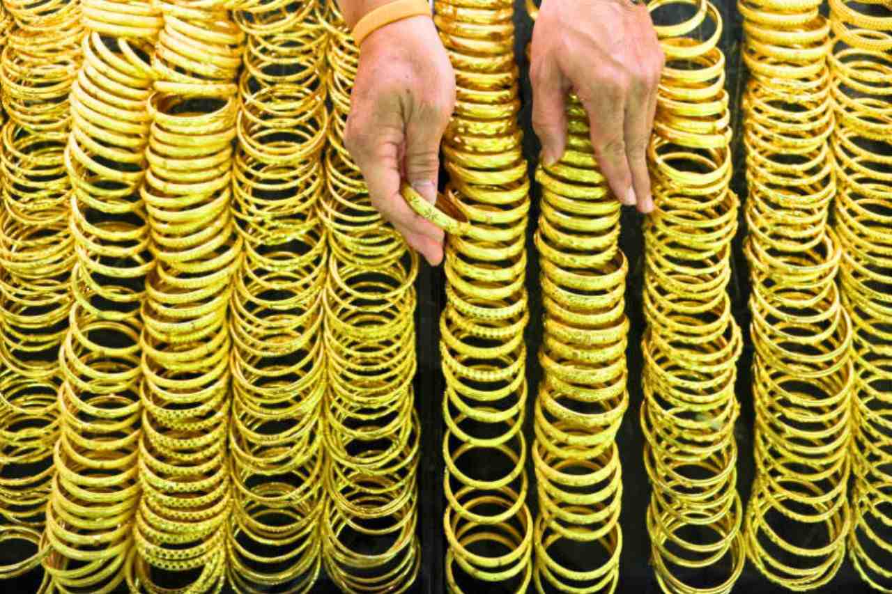 Un vendedor de oro exhibe pulseras de oro en una tienda especializada en el barrio chino de Bangkok