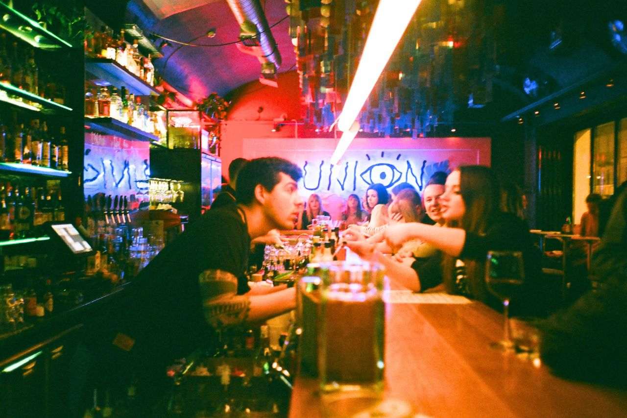 Waiter and customers in a bar.