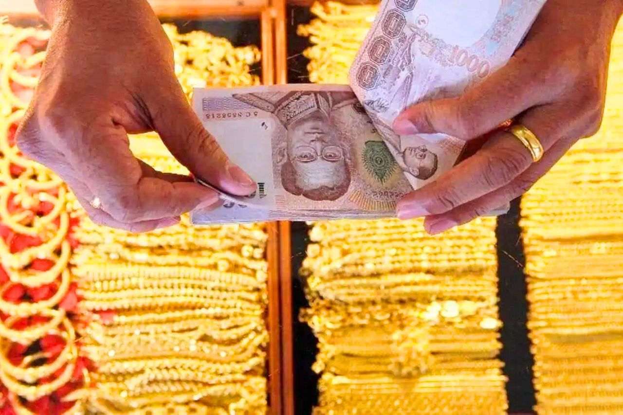Un vendeur d'or compte une liasse de billets de 1 000 bahts.