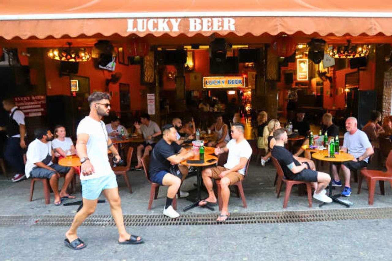 Des touristes discutent autour d'un verre dans un pub de Khaosan Road, à Bangkok