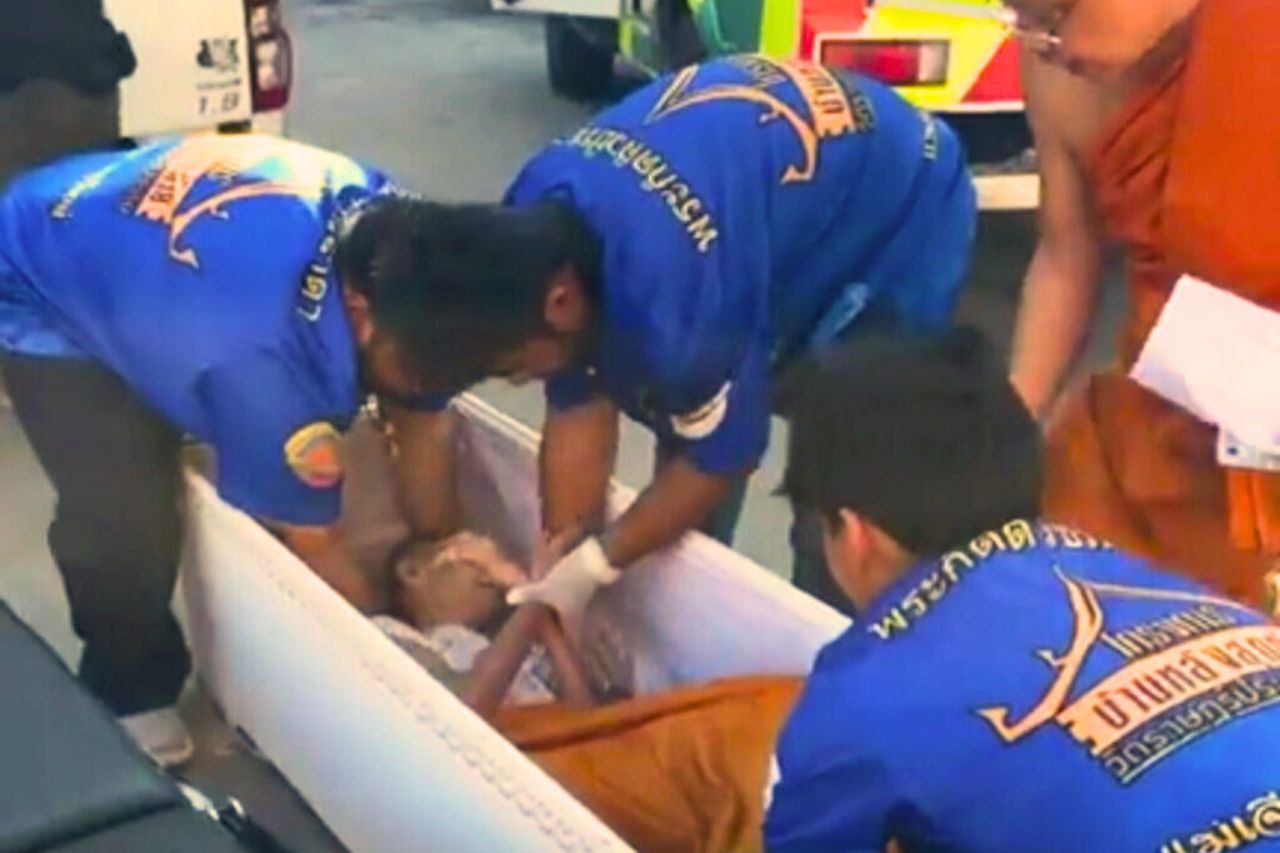 Les secouristes et un moine s'occupent de Chontirot Sakulku, la femme qui s'est réveillée dans son cercueil.