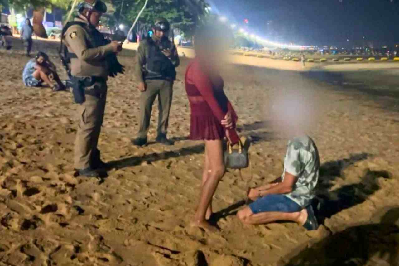 Police with Danish tourist and Thai woman on Jomtien beach in Pattaya.