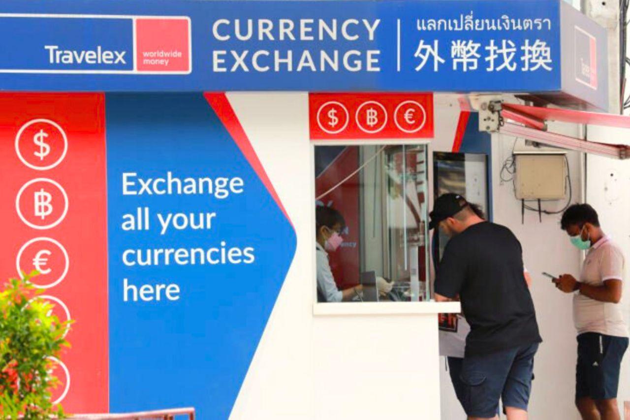 Ein ausländischer Tourist wechselt Geld in einem Wechselbüro in Bangkok