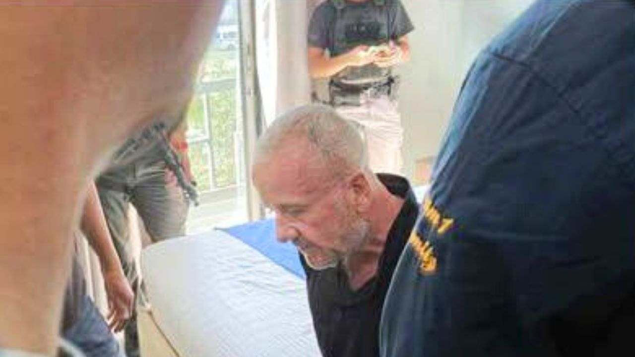 The Briton with police officers in his hotel room