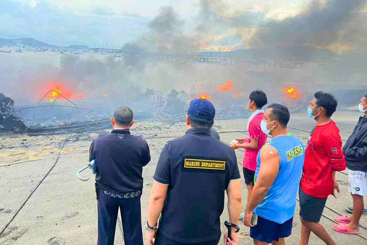 Des responsables et des passants sur les lieux de l'incendie de bateaux à Phuket le mercredi 7 janvier 2026