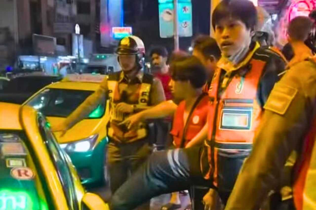 Des policiers viennent arrêter une femme armée maintenue enfermée dans un taxi par des chauffeurs de moto-taxi.