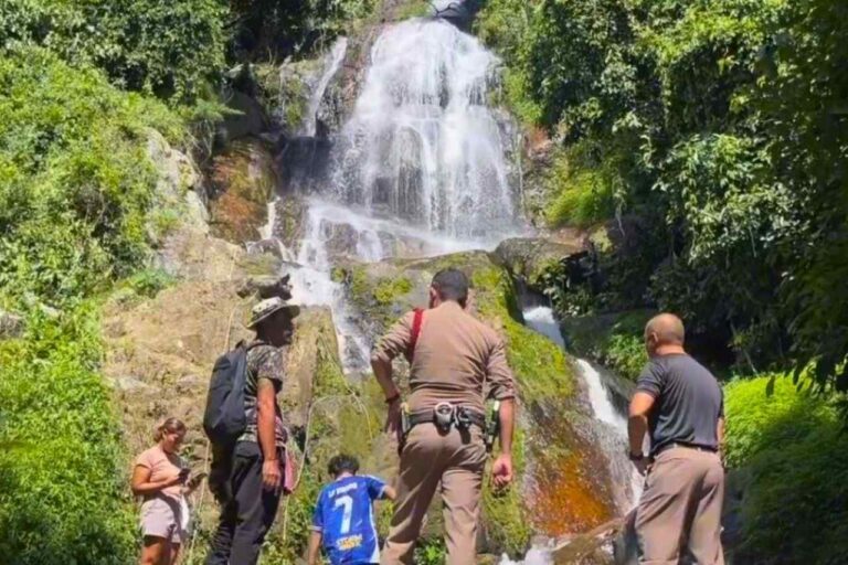 La compagne du touriste, entourée de policiers et de secouristes devant la cascade de Na Muang 2 à Koh Samui après l’accident