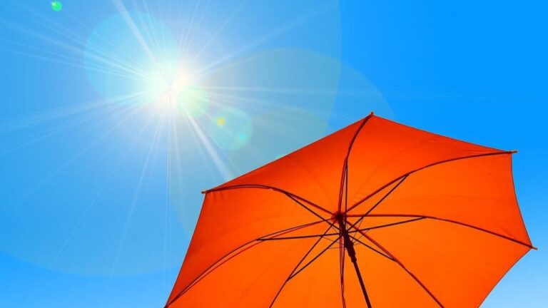 La Thaïlande entre officiellement dans sa saison chaude : l'été 5 Soleil intense et parasol dans un ciel bleu