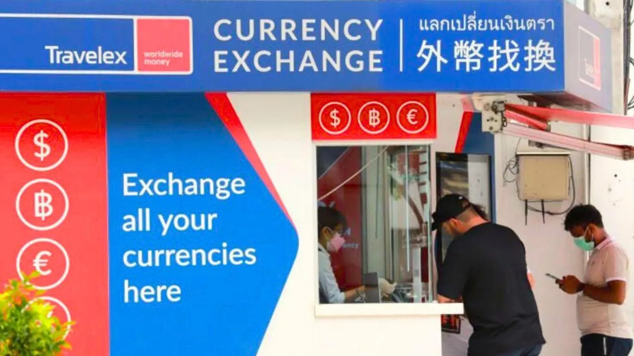 Un touriste étranger change de l'argent dans un bureau de change à Bangkok