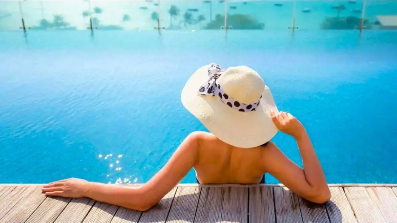 Touriste dans une piscine en face de la mer dans un hôtel de luxe en Thaïlande