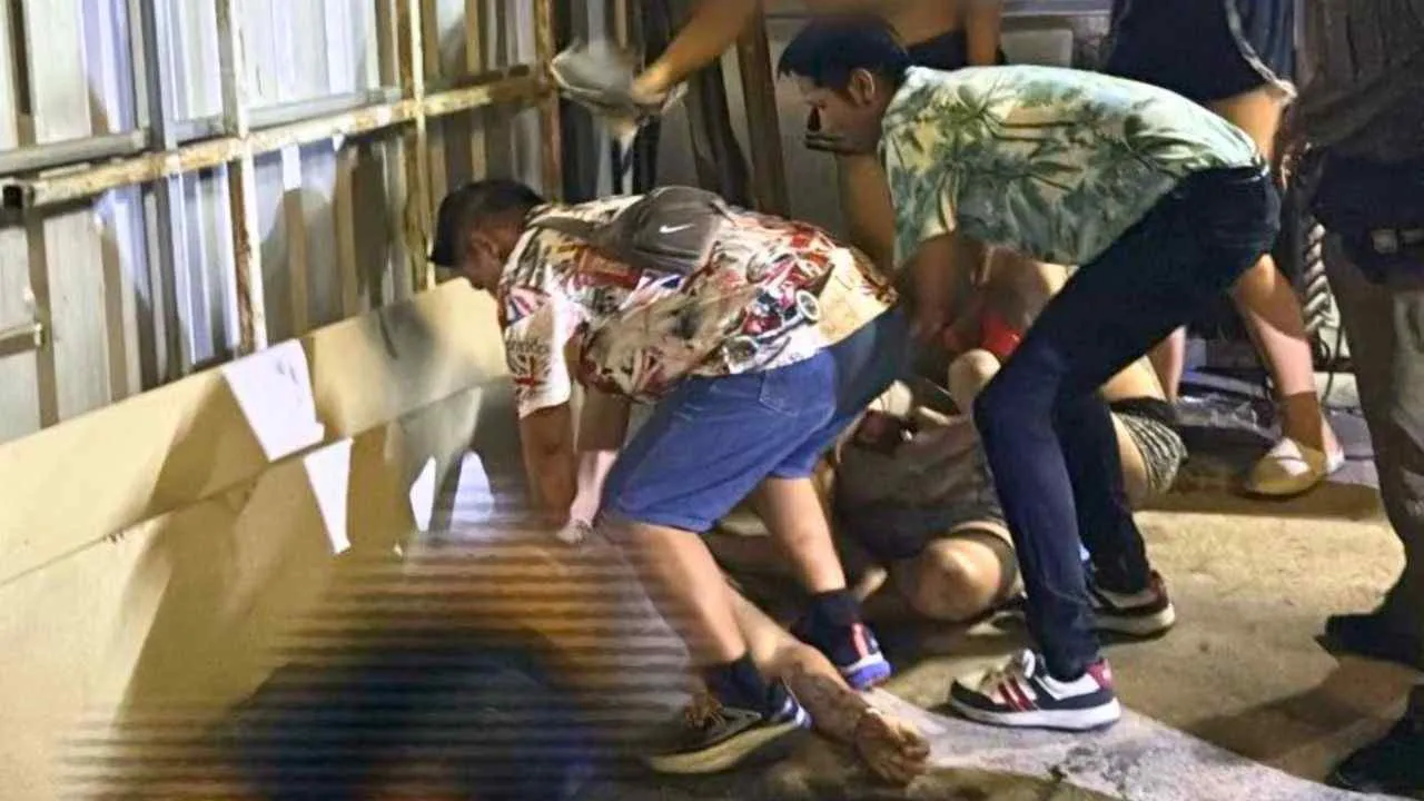 Des proches portent assistance à un commerçant blessé par balles près de Walking Street à Pattaya