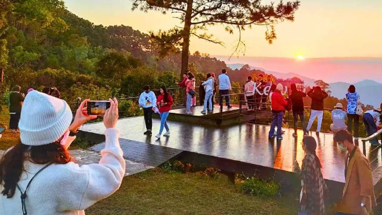 Des touristes observent le lever du soleil au point de vue de Kew Fin dans le parc national de Chae Son à Chiang Mai