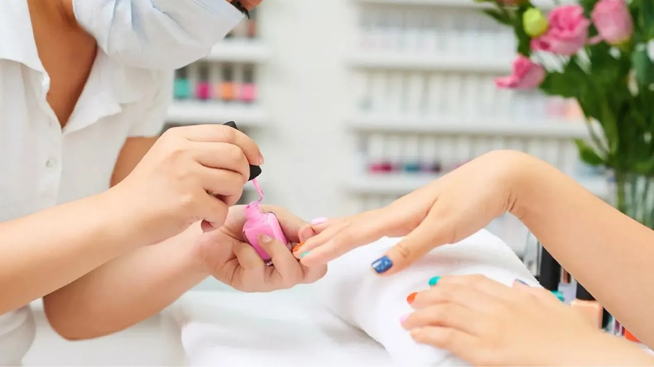 Une employée réalise une manucure dans un salon de beauté en Thaïlande