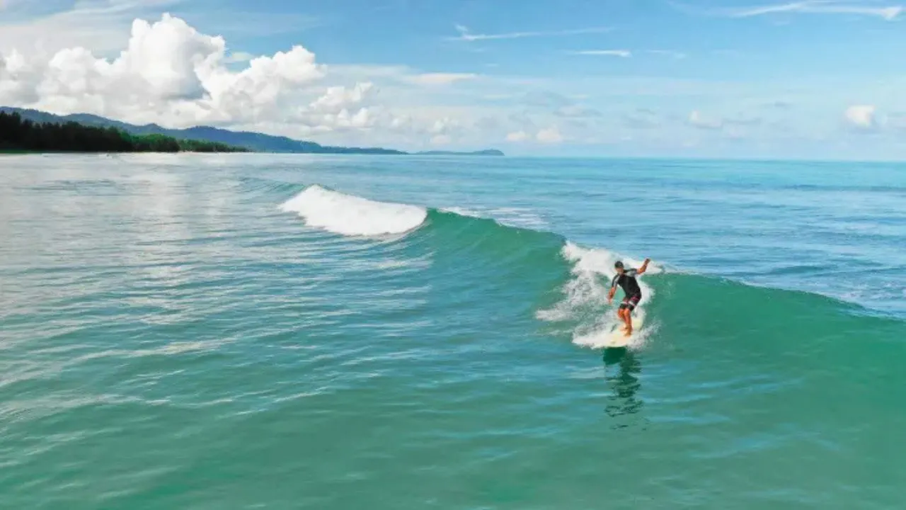 Un surfeur profite des vagues à Khao Lak en Thaïlande.
