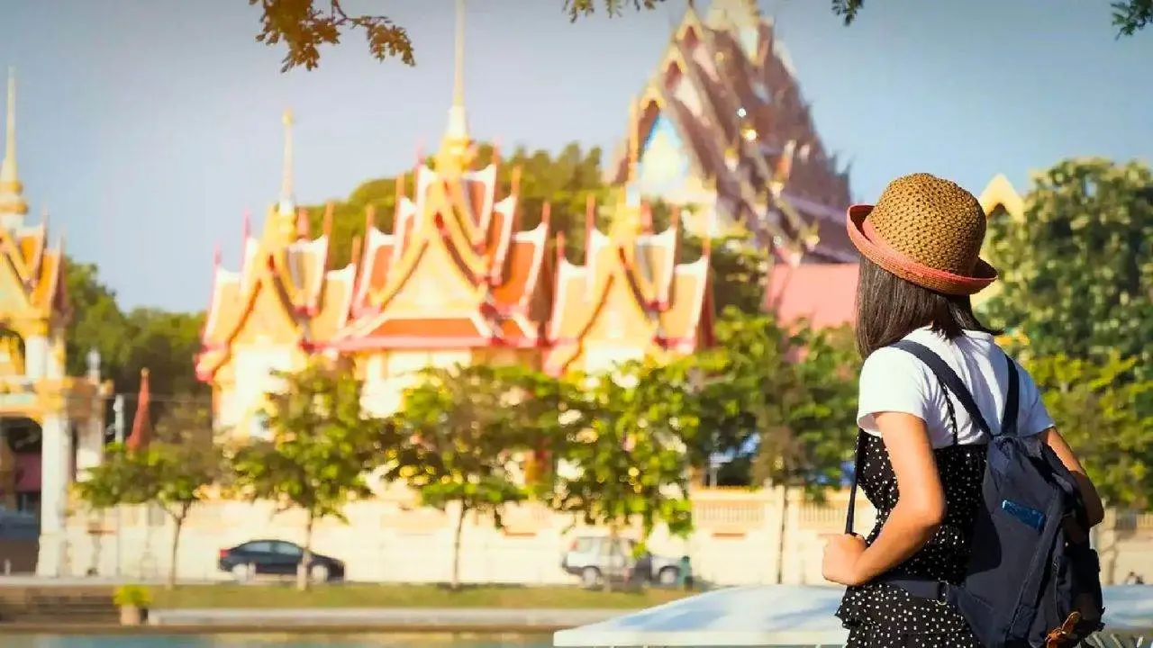Touriste observant un temple bouddhiste en Thaïlande