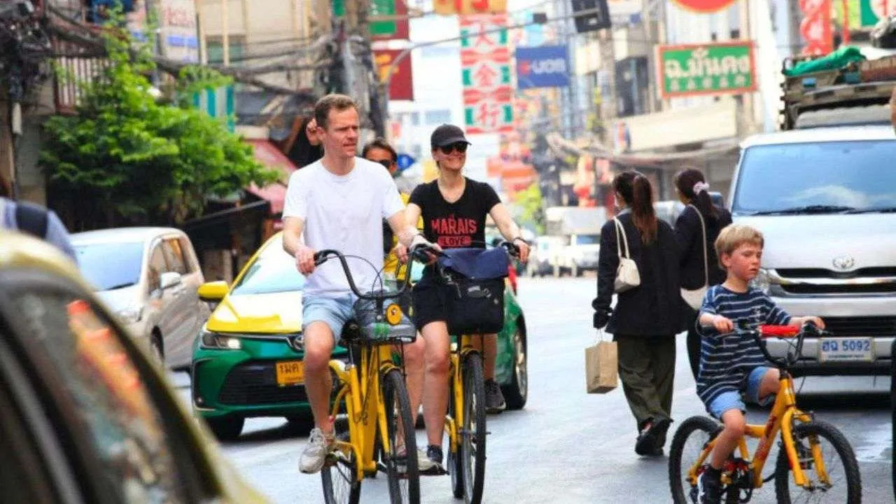Une famille de touristes se balade à vélo dans une ville de Thaïlande