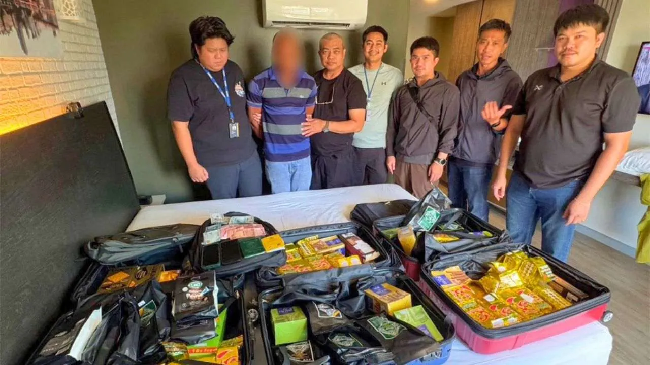 Police thaïlandaise présentant un suspect nigérian et des valises contenant de l'héroïne saisies lors du démantèlement d'un réseau international de trafic de drogue à Bangkok
