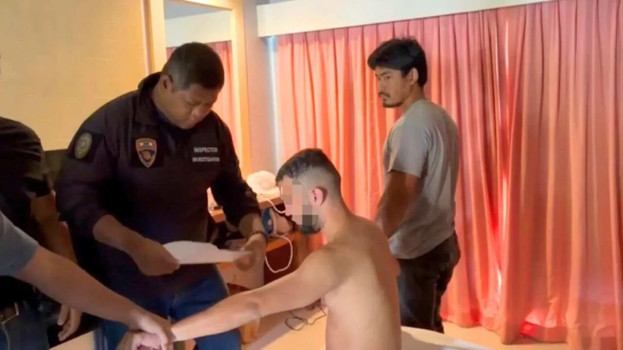 Enquêteurs de l'immigration thaïlandaise procédant à l'arrestation d'un ressortissant français recherché par Interpol dans sa chambre d'hôtel à Phuket