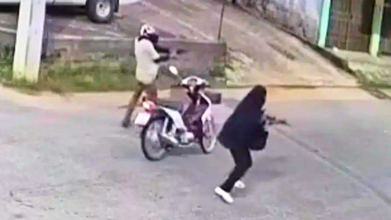 Un homme armé ouvre le feu près d'une moto lors de l'attaque contre un poste de contrôle à Narathiwat, dans le sud de la Thaïlande