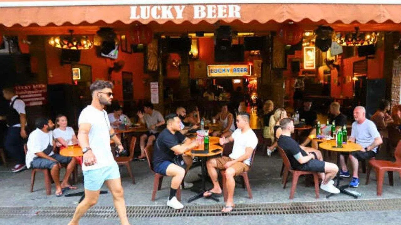 Des touristes discutent autour d'un verre dans un pub de Khaosan Road, à Bangkok