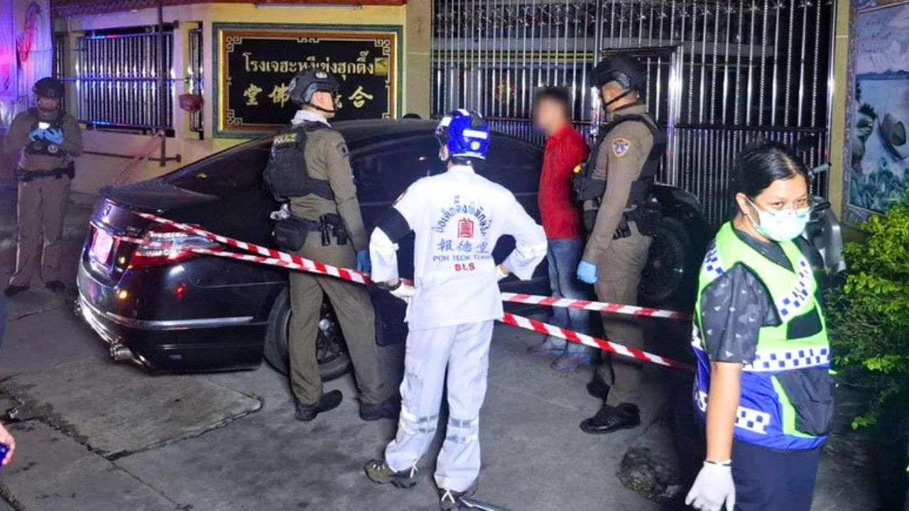 Policiers et secouristes autour de la voiture dans laquelle le corps d'une femme inconnue a été découvert à Samut Prakan