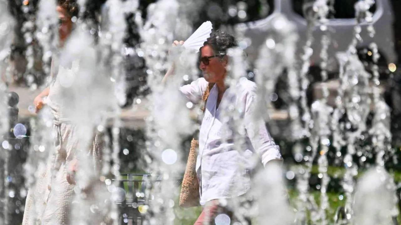 Une femme se protège du soleil près d'une fontaine pendant la canicule à Sofia, en Bulgarie