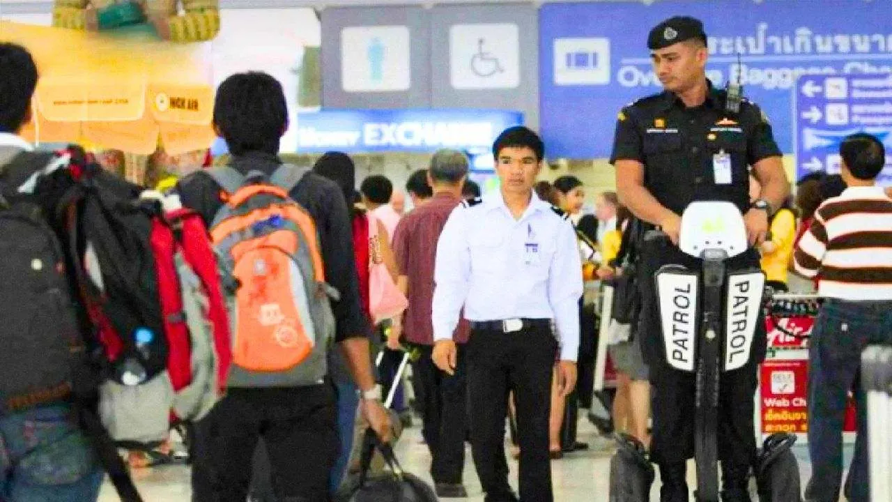 Agent de sécurité patrouillant dans un terminal d'aéroport en Thaïlande dans le cadre du renforcement des contrôles