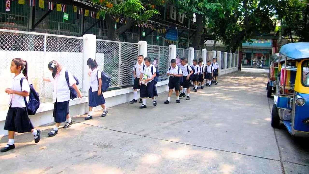 Des écoliers marchent devant une école