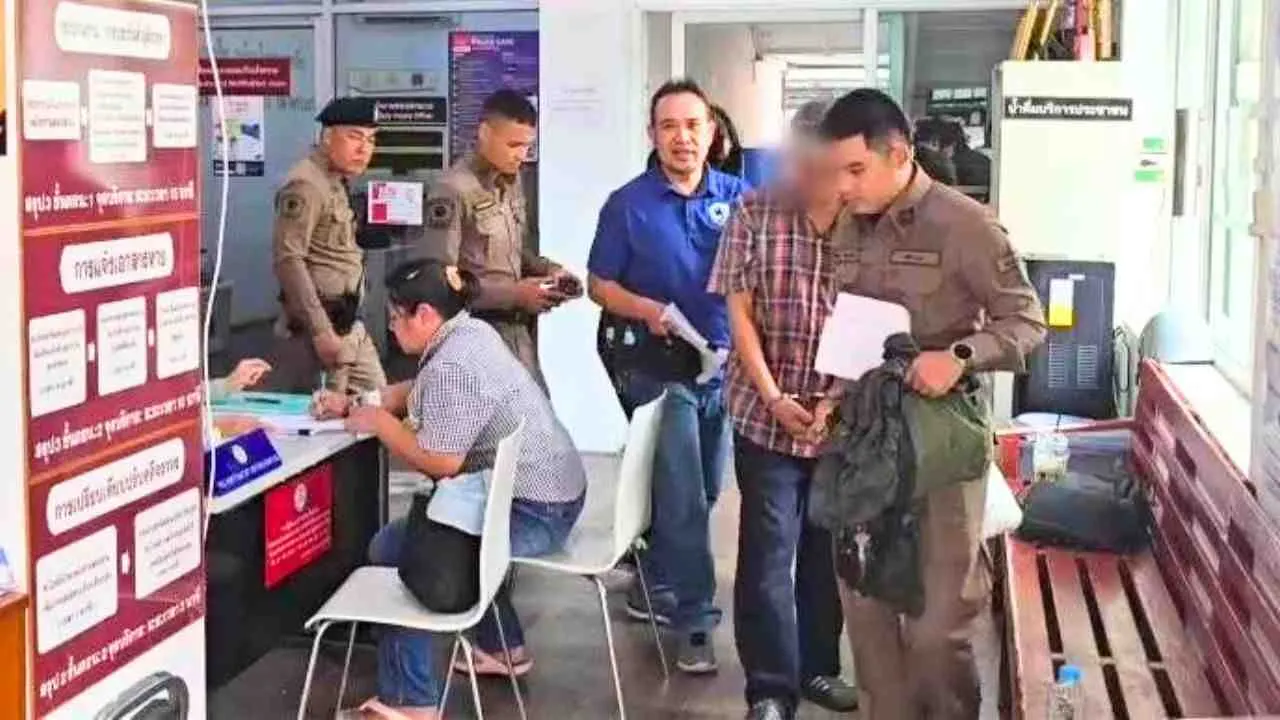 Un suspect escorté par la police thaïlandaise lors d'une opération visant un réseau de « faux pères » impliqué dans l'enregistrement frauduleux de bébés chinois comme citoyens thaïlandais