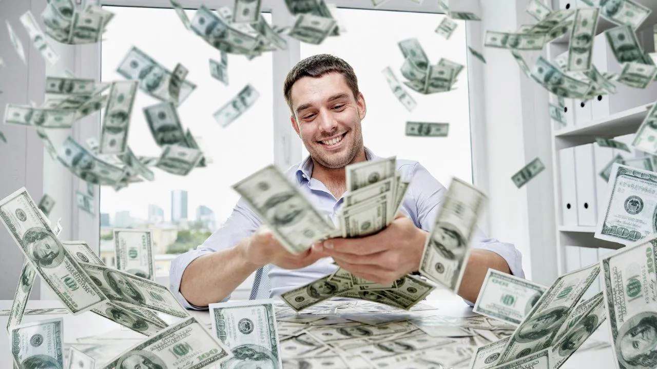 Homme comptant des billets de 100 dollars sous une pluie de billets