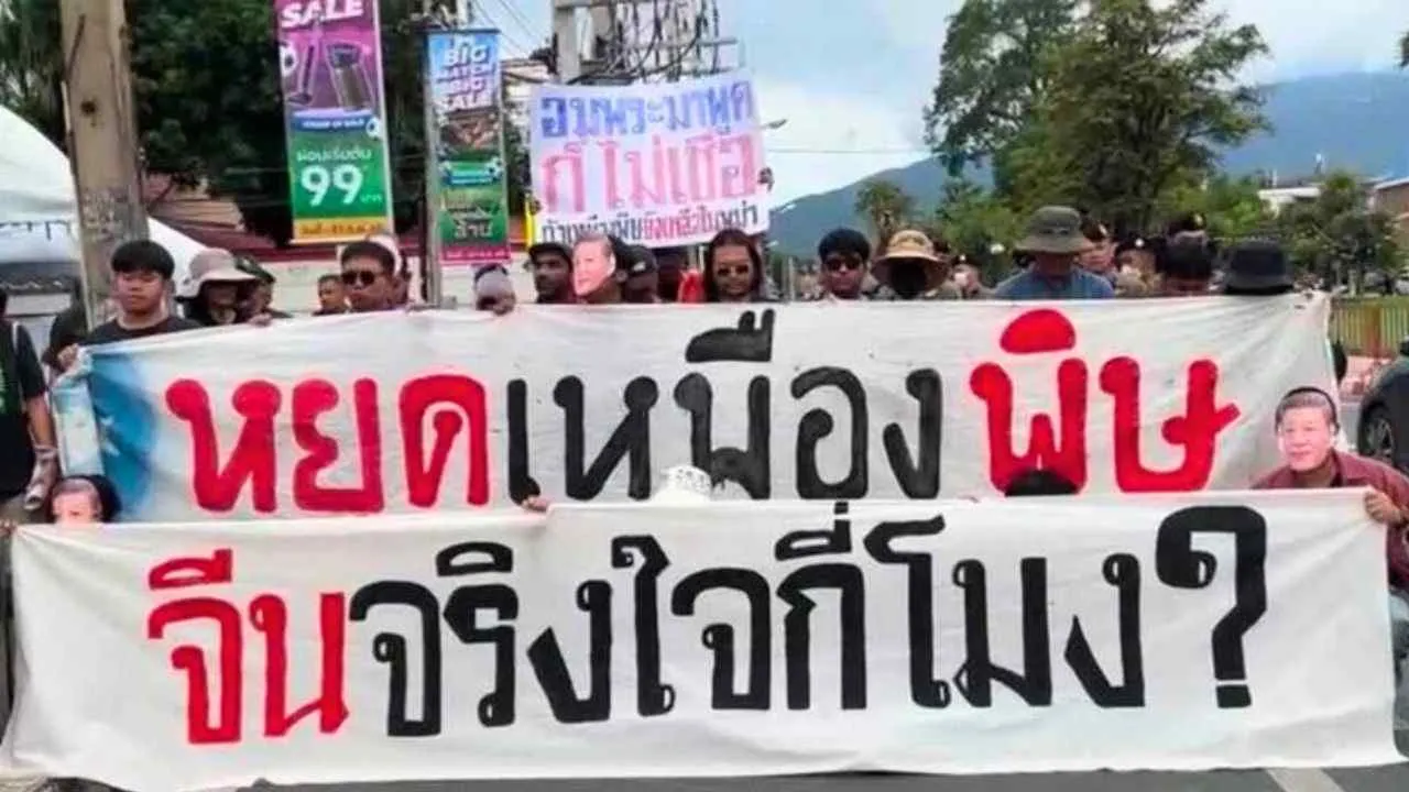 Manifestants défilant à Chiang Mai avec une banderole appelant à l'arrêt des mines responsables de la pollution à l'arsenic des rivières du nord de la Thaïlande