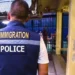 Agent de la police de l'immigration thaïlandaise devant une zone sécurisée