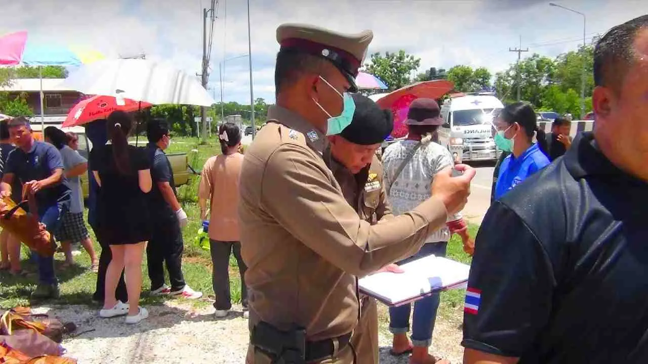 Un policier relève les premiers éléments de l'enquête après l'accident qui a coûté la vie à neuf moines dans la province de Mukdahan