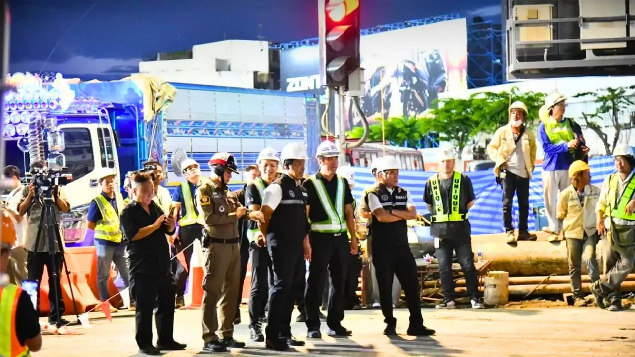 Responsables, policiers et équipes techniques inspectent le chantier de la ligne violette du métro après un affaissement de terrain à Bangkok