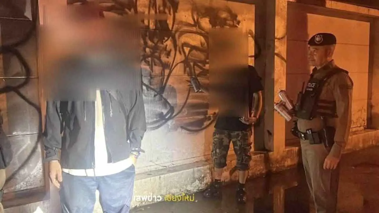 Deux touristes étrangers interpellés par la police devant le mur d'une école taguée à Chiang Mai
