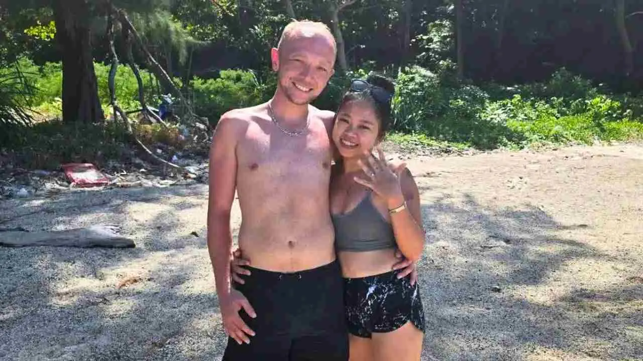 Kyle Campbell et sa fiancée Kannika Masasai posent sur une plage en Thaïlande